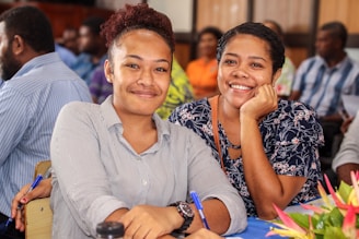 a couple of women sitting next to each other at a table