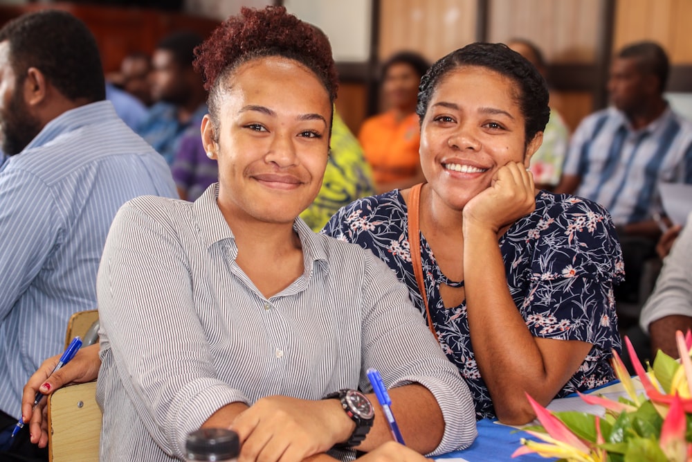 a couple of women sitting next to each other at a table