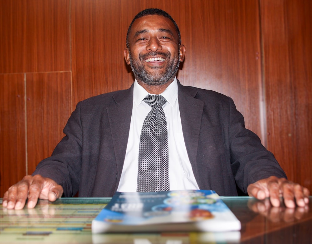 a man in a suit and tie sitting at a desk