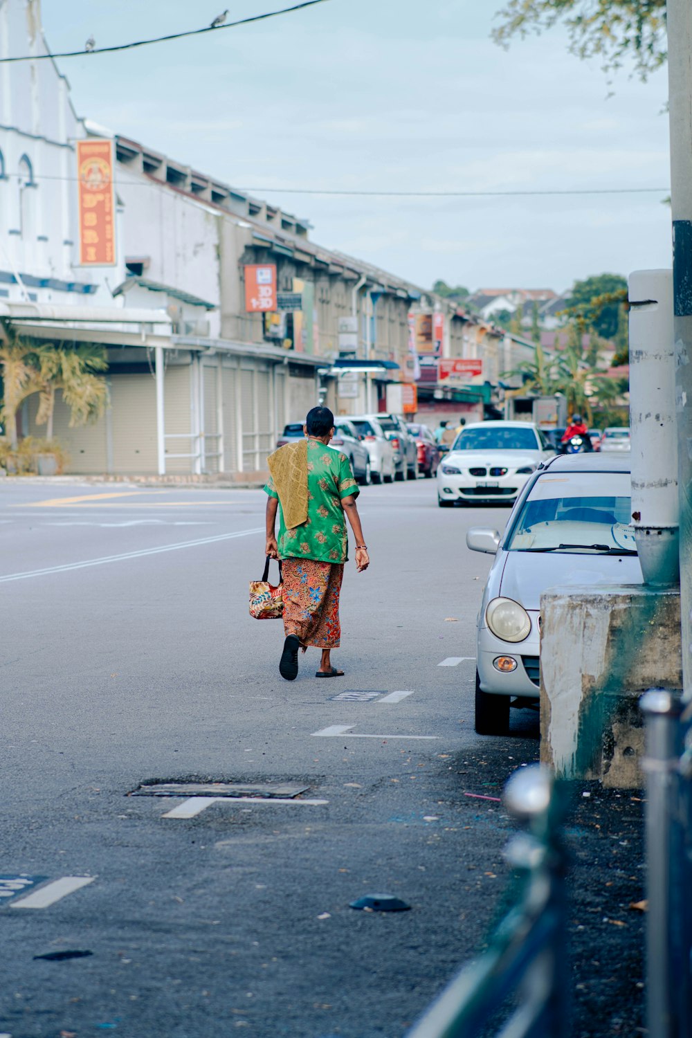 a woman walking down a street holding a purse