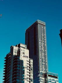 a group of tall buildings with a plane flying in the sky