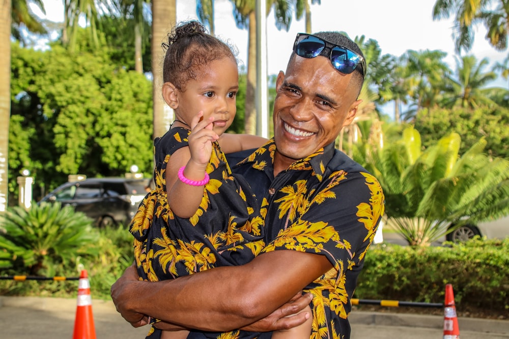 a man holding a little girl in his arms