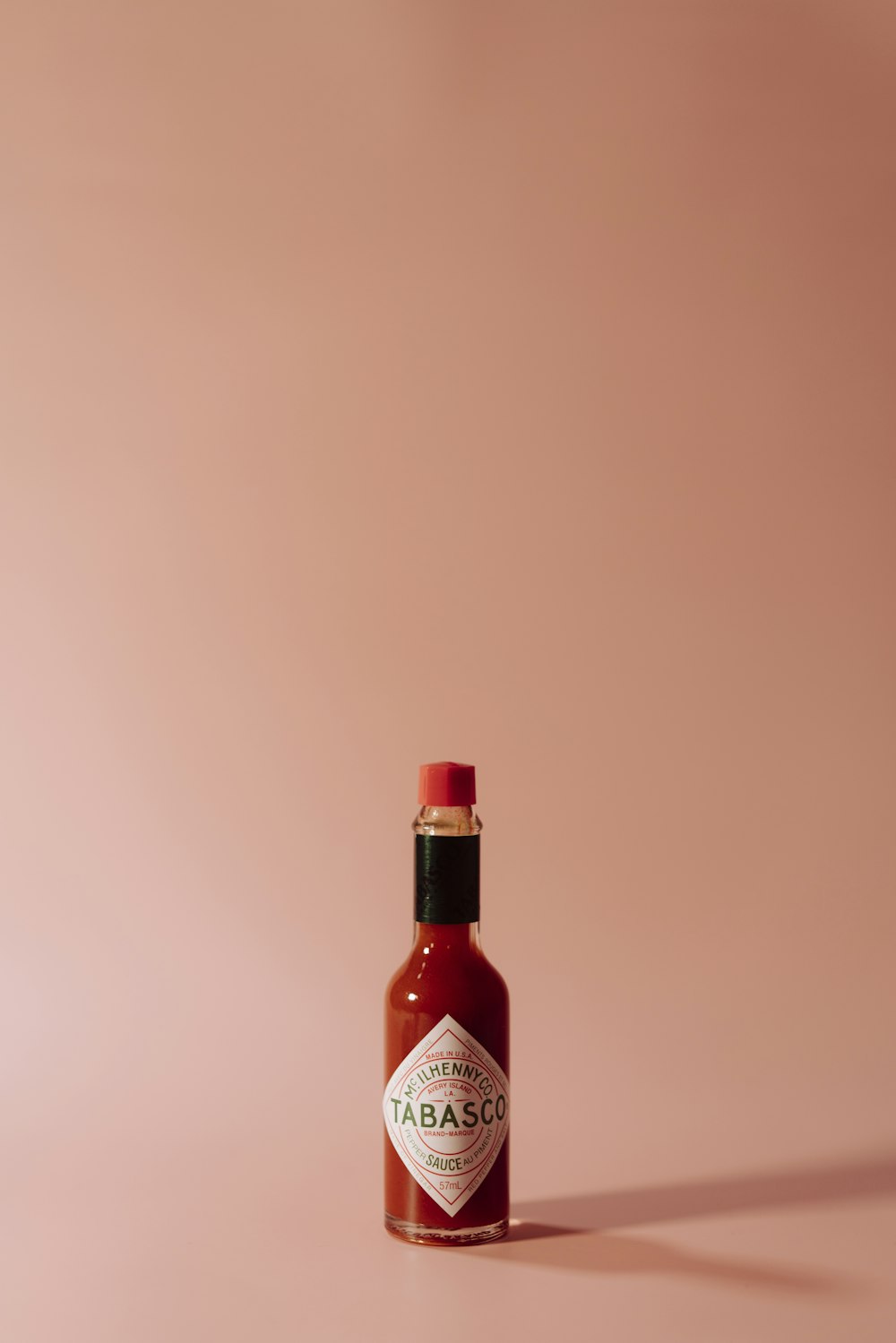 a bottle of tabbabata sauce on a pink background