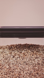 Packaging of organic oat flakes displayed on a rustic wooden table with oat stalks