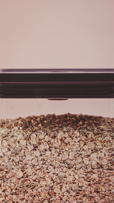 Artisan oat flour bags stacked neatly with sprigs of fresh oats in the background.