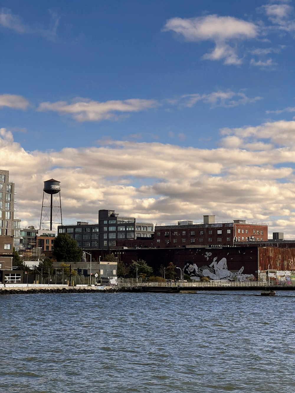 a large body of water with buildings in the background