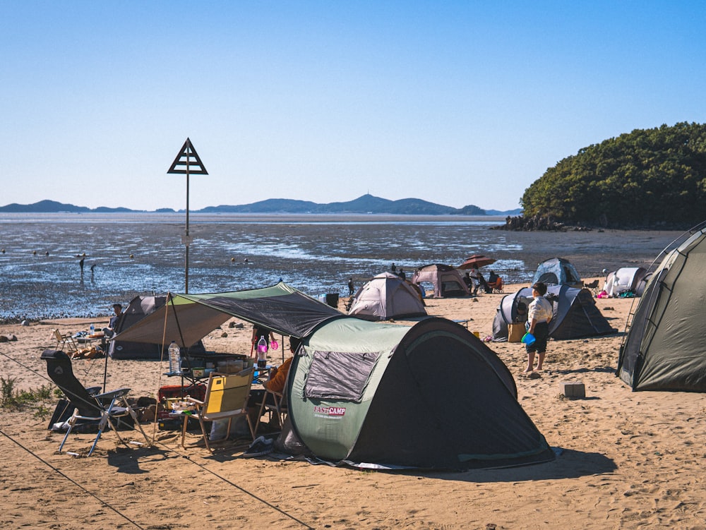 a group of tents sitting on top of a sandy beach