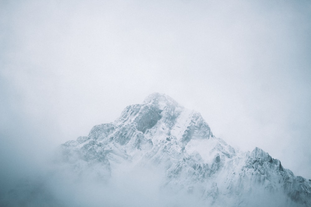 a very tall mountain covered in snow on a cloudy day