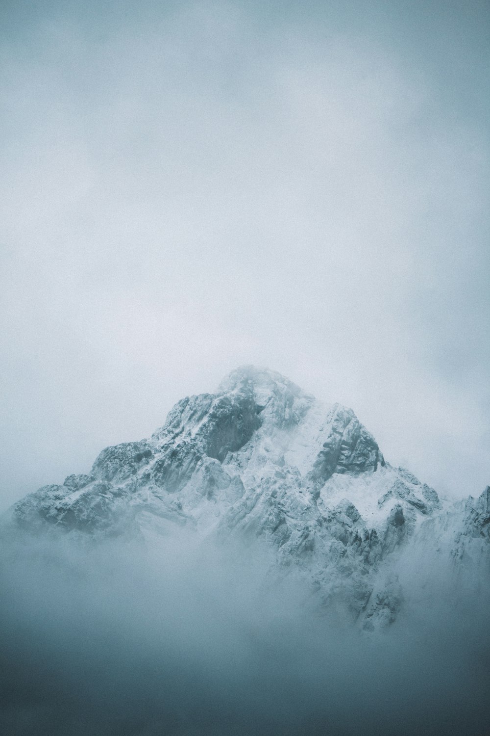 a large mountain covered in snow on a cloudy day