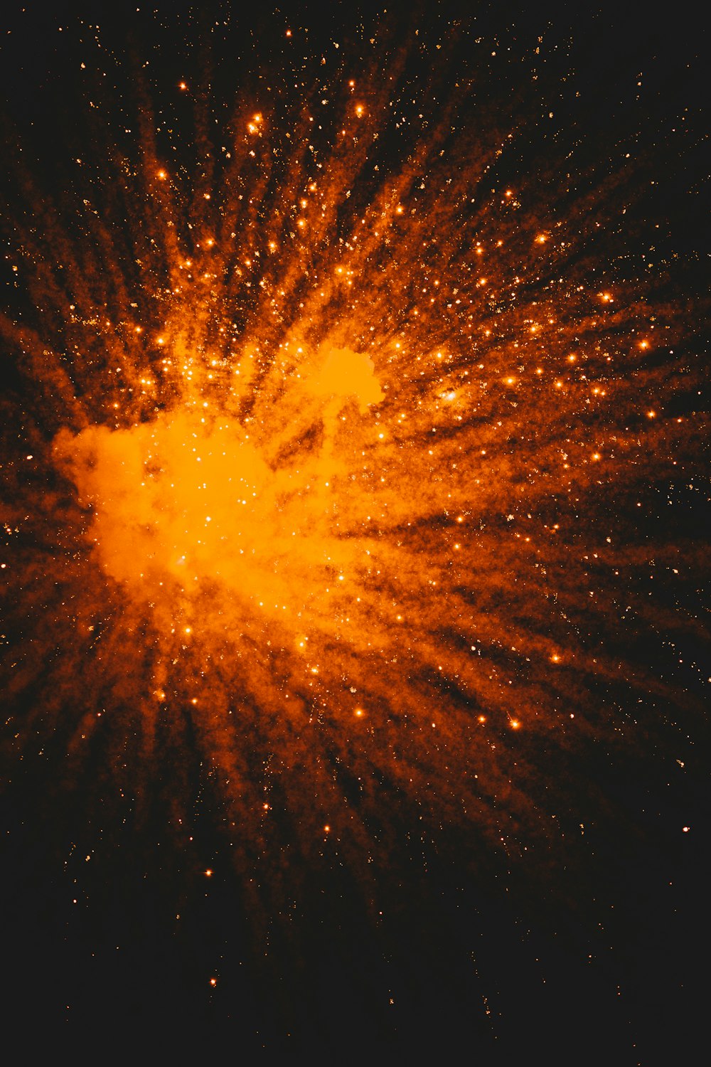 an orange and yellow star burst in the night sky