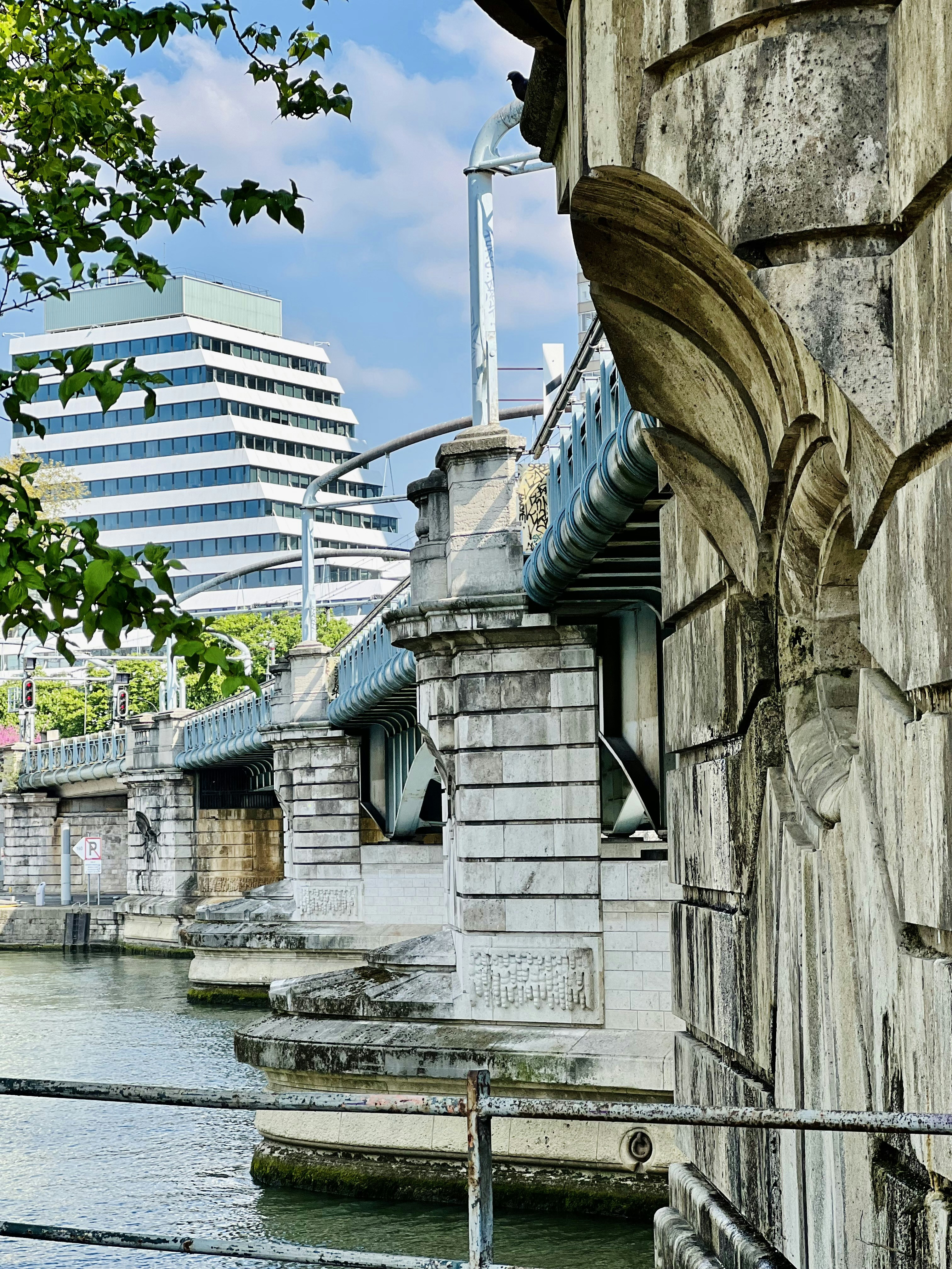 a bridge over a body of water next to a tall building