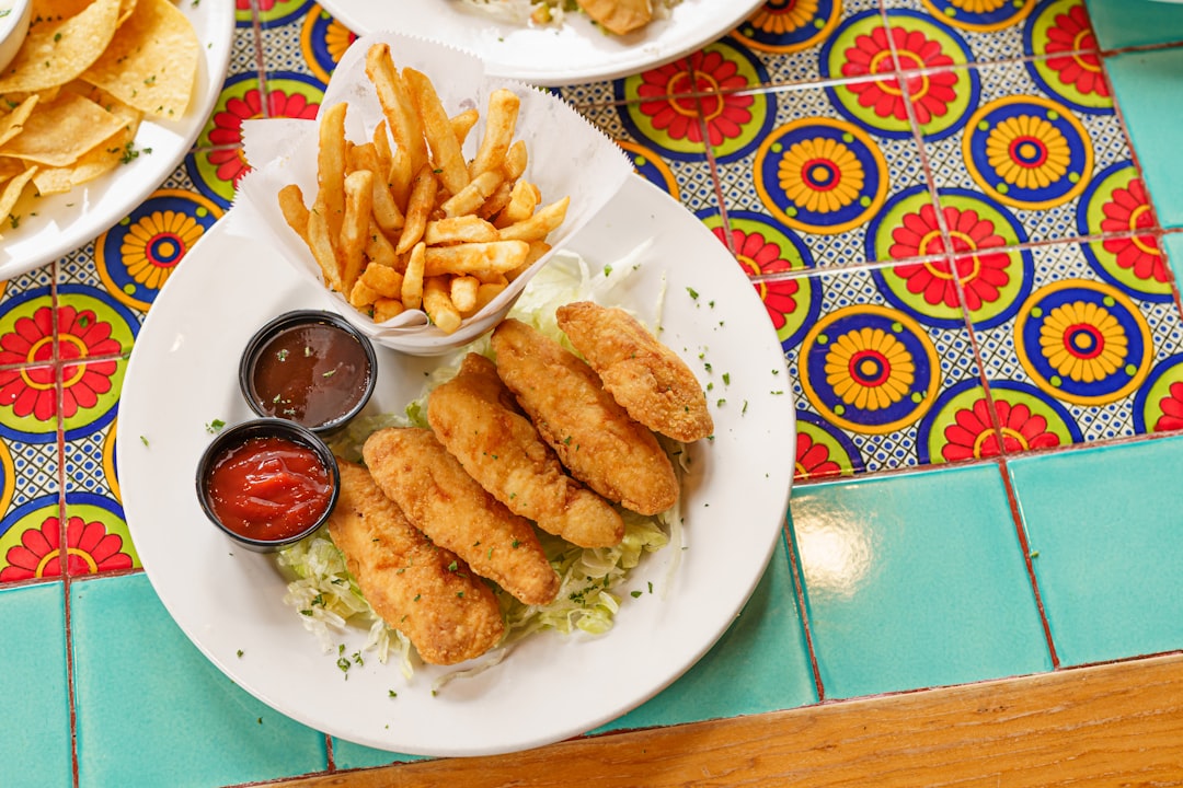 a plate of food on a table with chips and ketchup