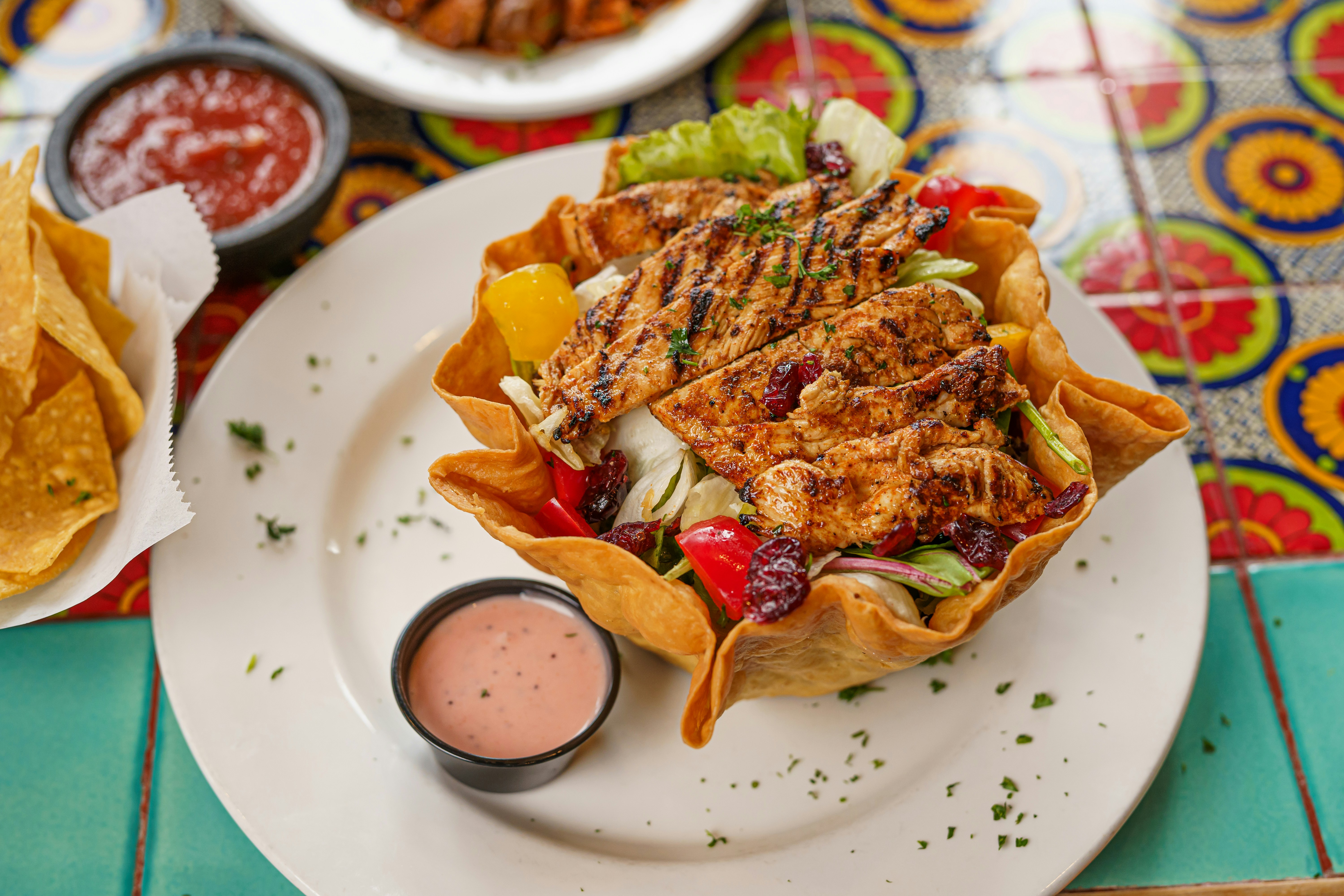 a plate of food on a table with a bowl of salsa