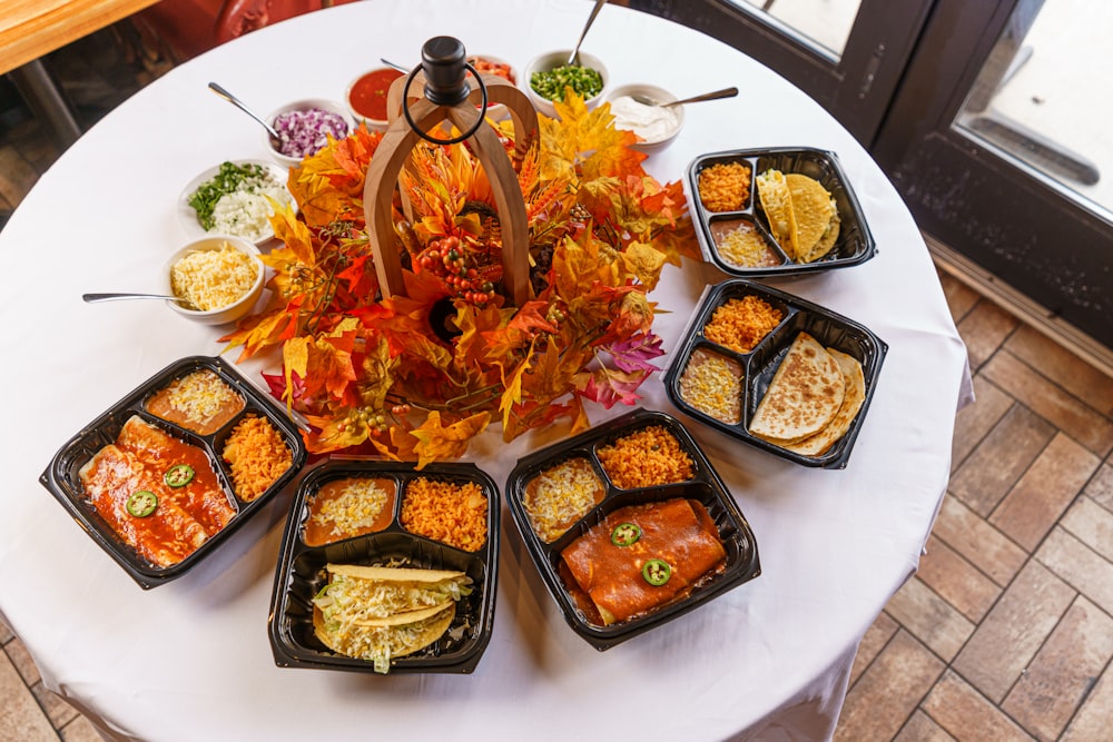 a white table topped with trays of food