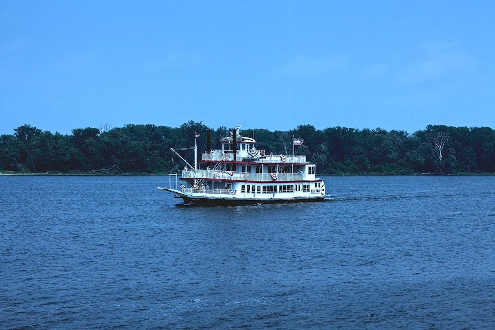 a large white boat floating on top of a lake