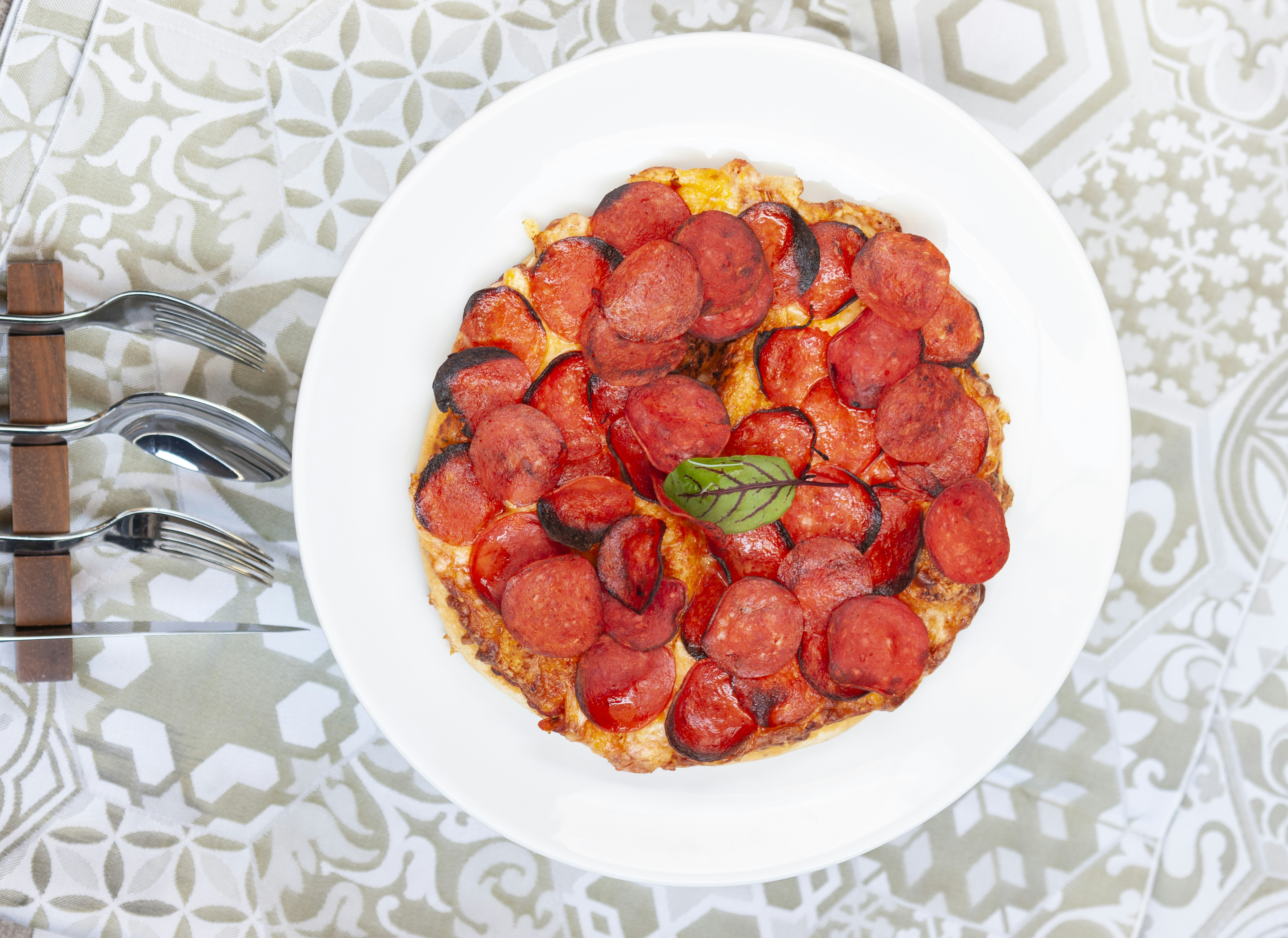 a white plate topped with a pizza covered in toppings