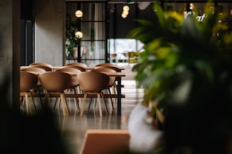 Dining area with soft rust-orange lighting and contemporary chairs around a wooden table.