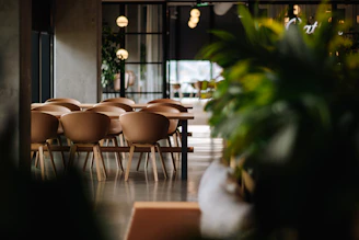 A sleek dining area with a polished wooden table and matching chairs under soft lighting.