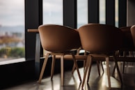 A set of elegant wooden dining chairs in a bright room.