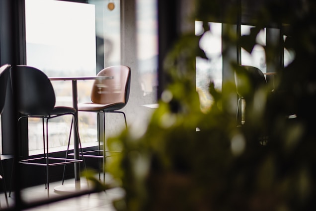 A sleek, modern restaurant interior with natural green leaf accents and elegant minimalist design.