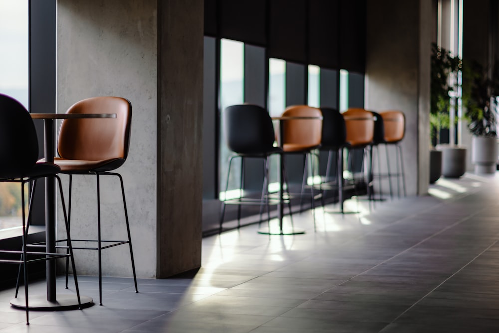 a row of bar stools sitting next to a window