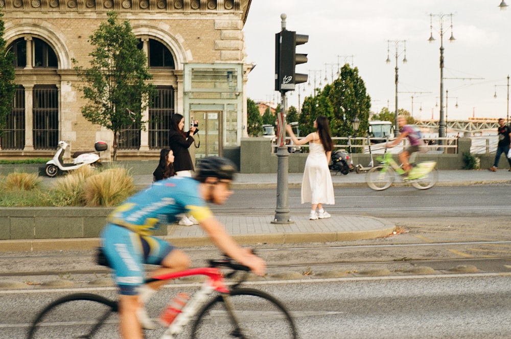 a man riding a bike down a street next to a traffic light