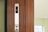 A wooden elevator panel with vertical grooves features a modern display indicating the number 6 in illuminated digits. Below the display, there are buttons with arrows pointing up and down, set against a sleek metallic strip.