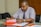 a man sitting at a table with papers in front of him