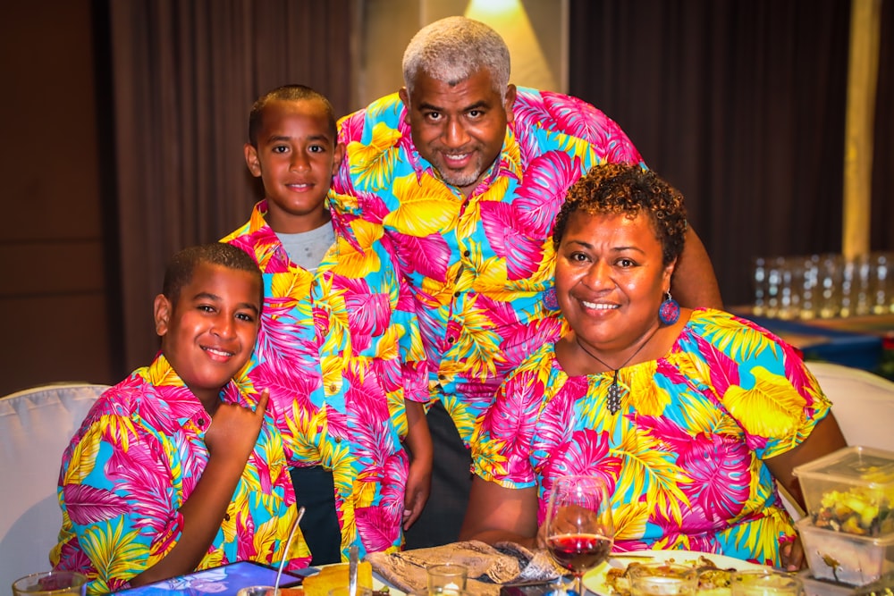 a group of people standing around a table with food