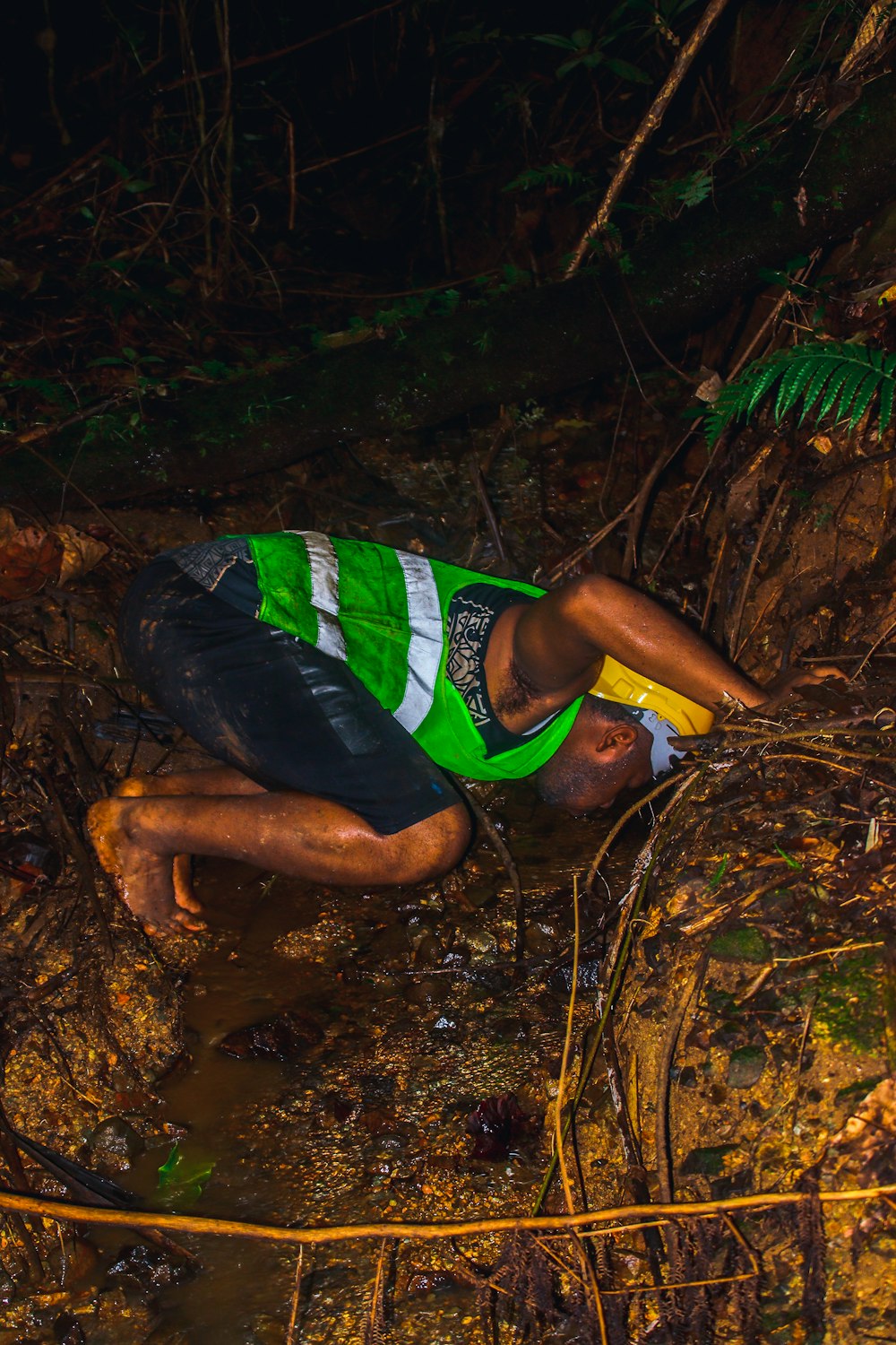 a man laying on the ground in the woods