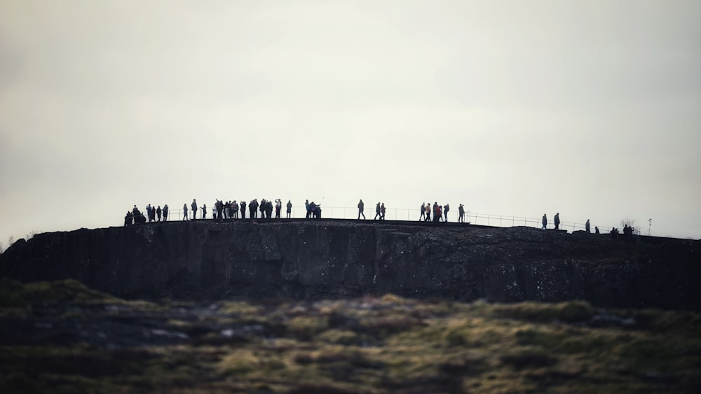 a group of people standing on top of a cliff