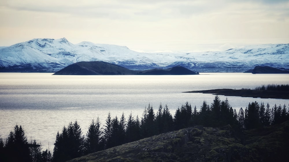 a large body of water surrounded by snow covered mountains