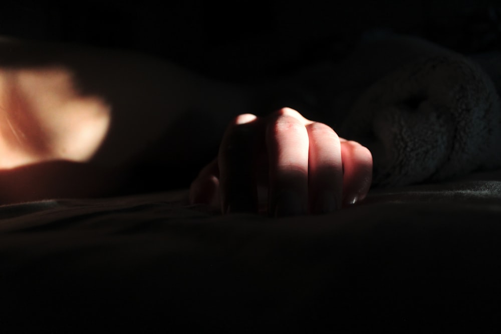 a person laying on a bed in the dark