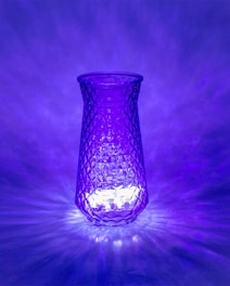 Close-up of a colorful, repurposed glass vase glowing softly in natural light.