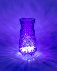 Close-up of a colorful, repurposed glass vase glowing softly in natural light.