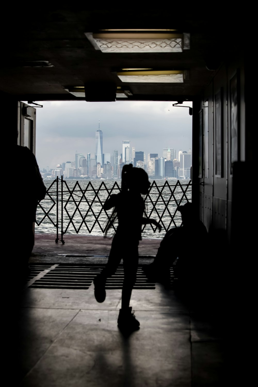 a silhouette of a child running towards a city