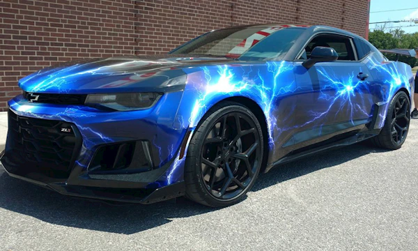 A sleek sports car with a custom bright blue paint job parked in an urban setting.