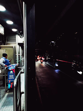 A professional security guard attentively monitoring a busy urban street at dusk.
