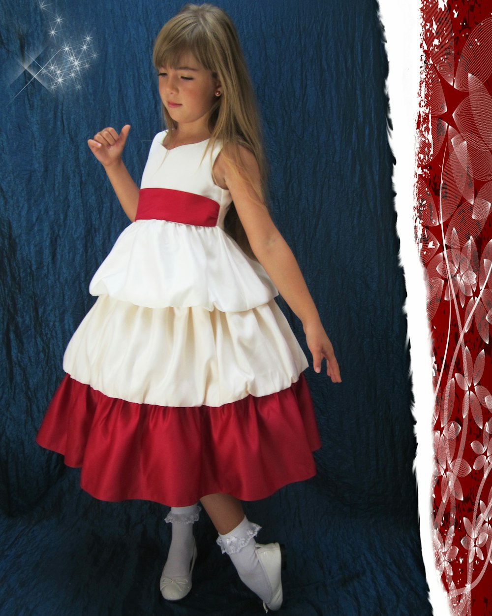 a little girl dressed in a white and red dress