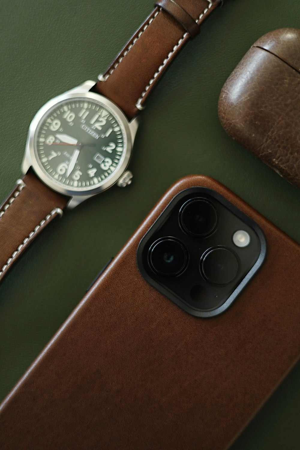 a watch sitting on top of a table next to a phone