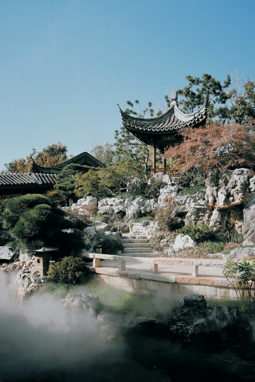 a scenic view of a chinese garden with a pagoda in the background