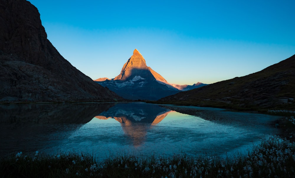 a mountain is reflected in the still water of a lake