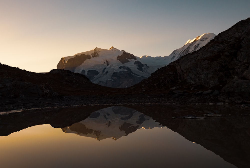 a mountain range with a lake in the foreground