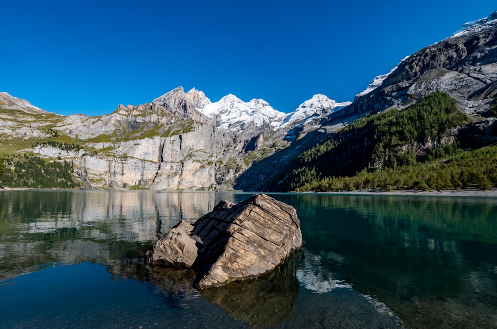 una grande roccia seduta in mezzo a un lago