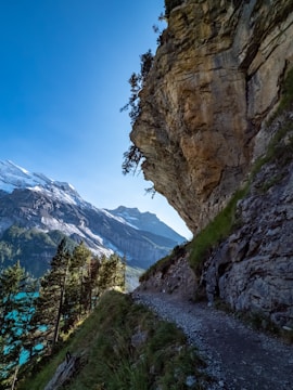 Runners crossing a rugged mountain trail with panoramic views of the Tarentaise massif.