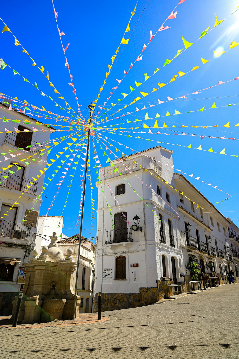 a street scene with a building and a kite in the air