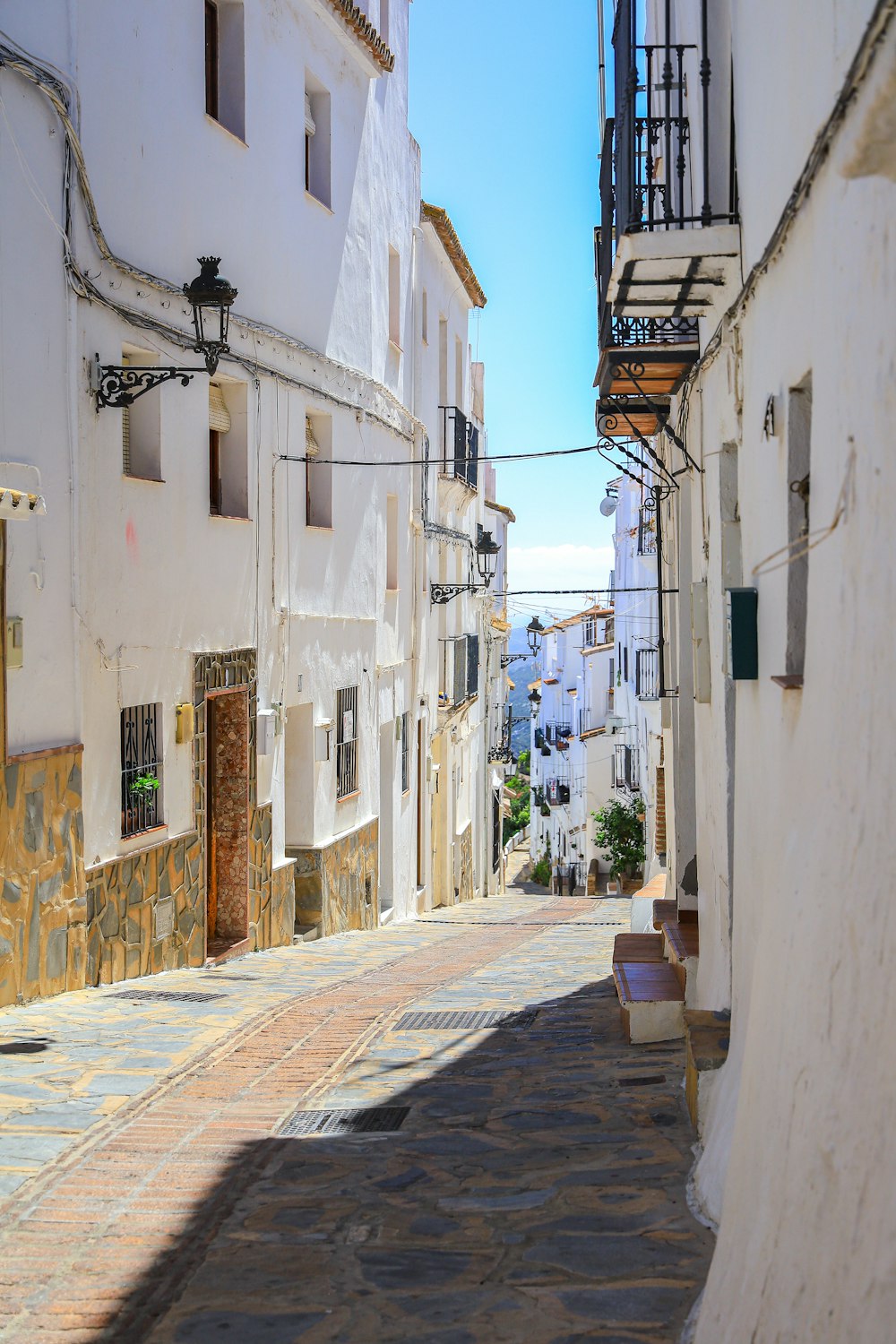 a narrow street with white buildings on both sides