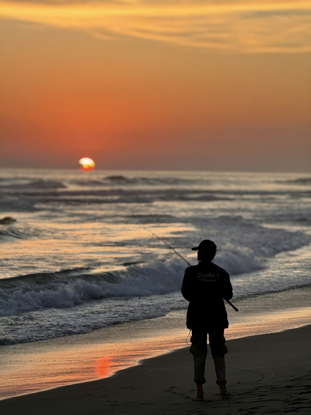 a person standing on a beach with a kite