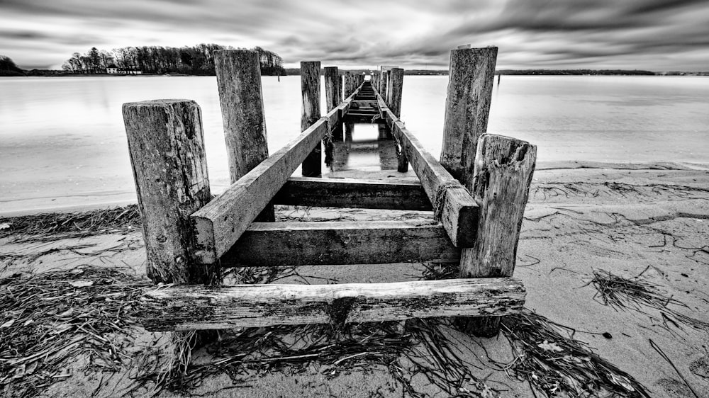 a wooden dock sitting on top of a sandy beach