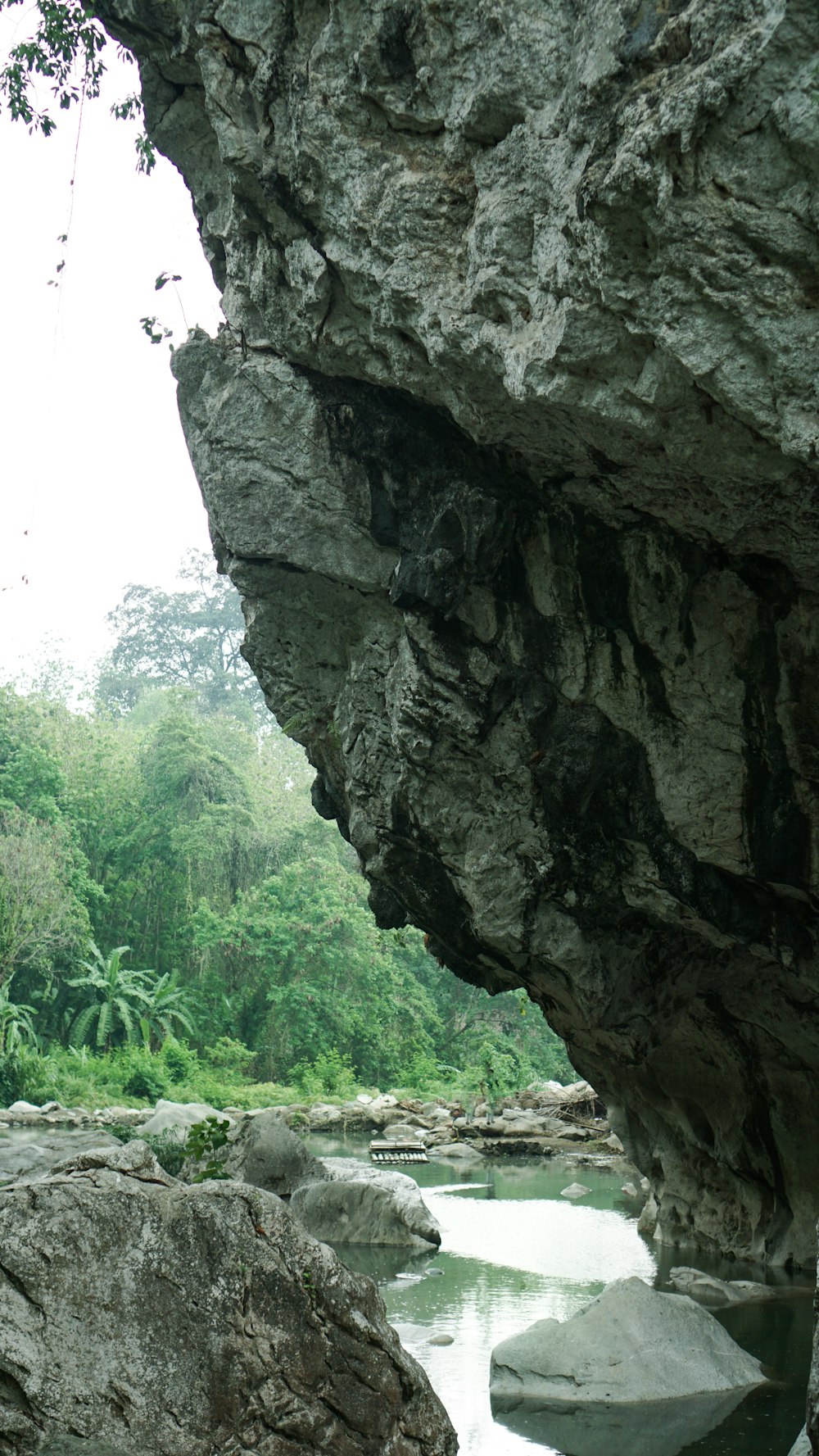 a river flowing under a large rock formation